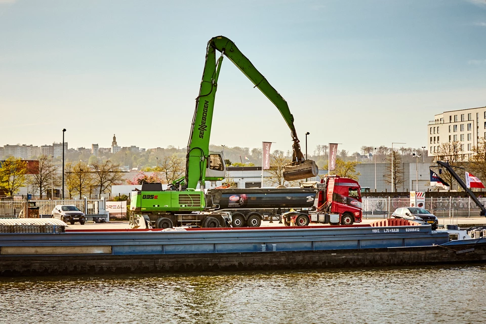 Transbordement de matériaux de construction entre péniche et camion à Bruxelles